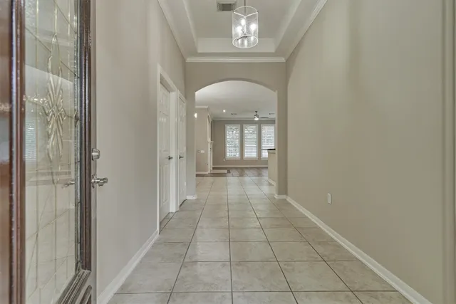 a view of a hallway with wooden floor and a chandelier