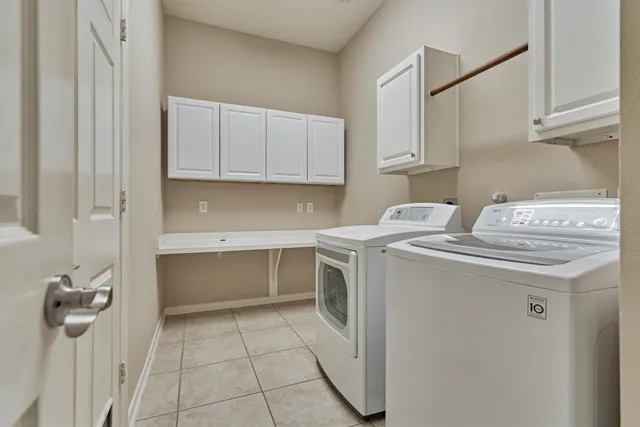 a utility room with cabinets washer and dryer