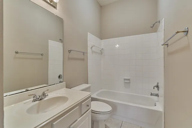 a bathroom with a bathtub shower sink mirror vanity and toilet