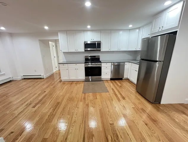 a large kitchen with a refrigerator a stove top oven a sink and dishwasher