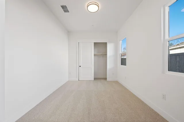 an empty room with windows and closet