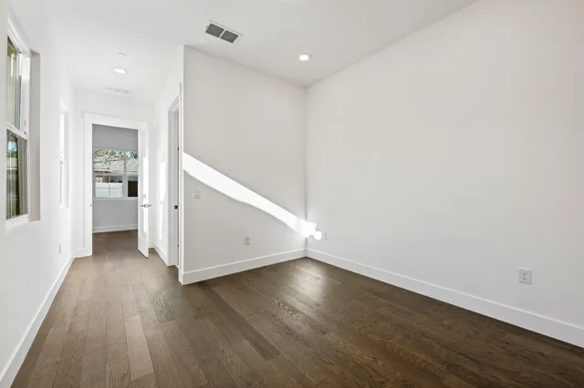 a view of an empty room with wooden floor