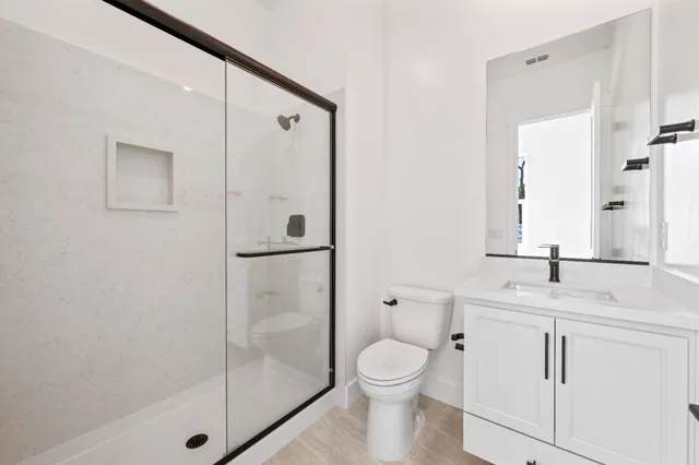 a bathroom with a granite countertop sink toilet and shower