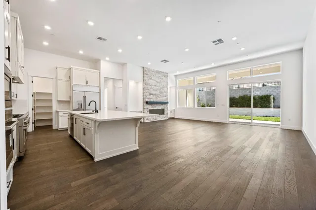 a large white kitchen with a large window and stainless steel appliances