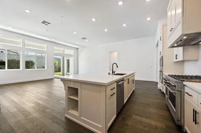a kitchen with stainless steel appliances granite countertop a stove and a sink