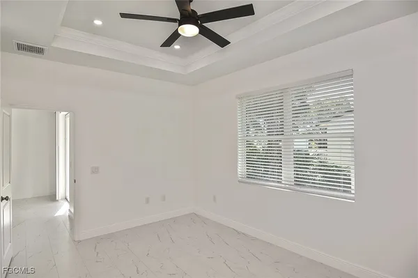 a view of an empty room with a window and a ceiling fan