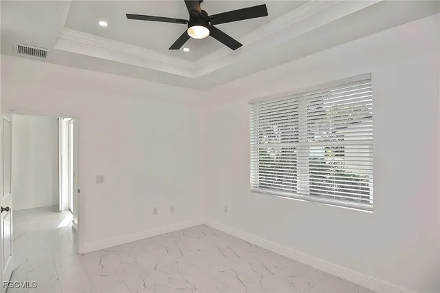 a view of an empty room with a window and a ceiling fan
