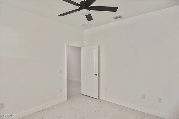 an empty room with a ceiling fan and carpet