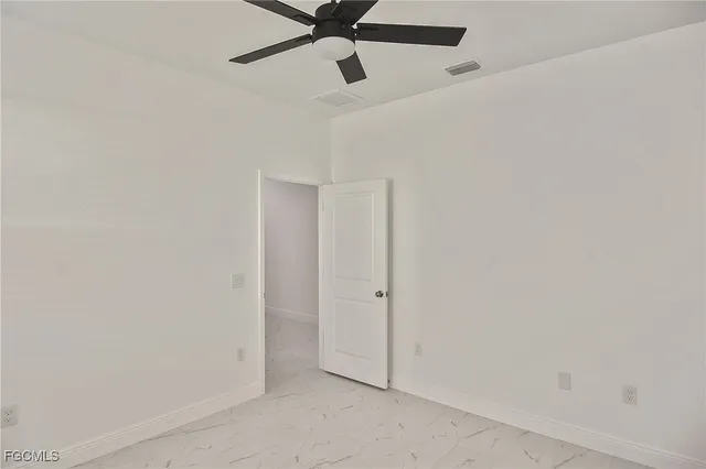 an empty room with a ceiling fan and carpet
