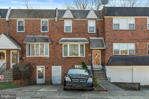 a car parked in front of a brick house
