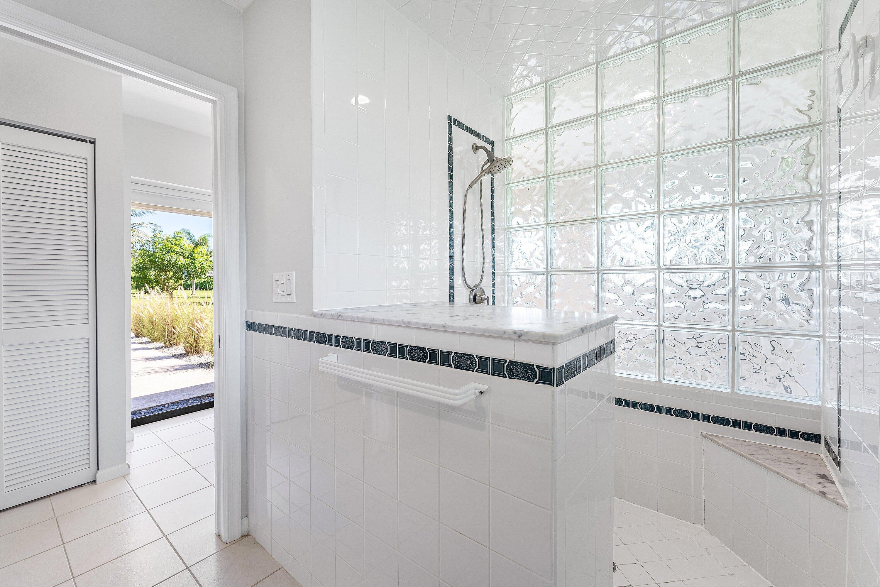 6048 Wood Lake Road Jupiter, FL 33458 - Photo 14 of 31 a bathroom with a granite countertop sink and a shower