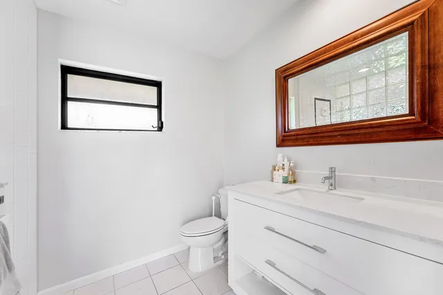 a bathroom with a toilet sink vanity and mirror