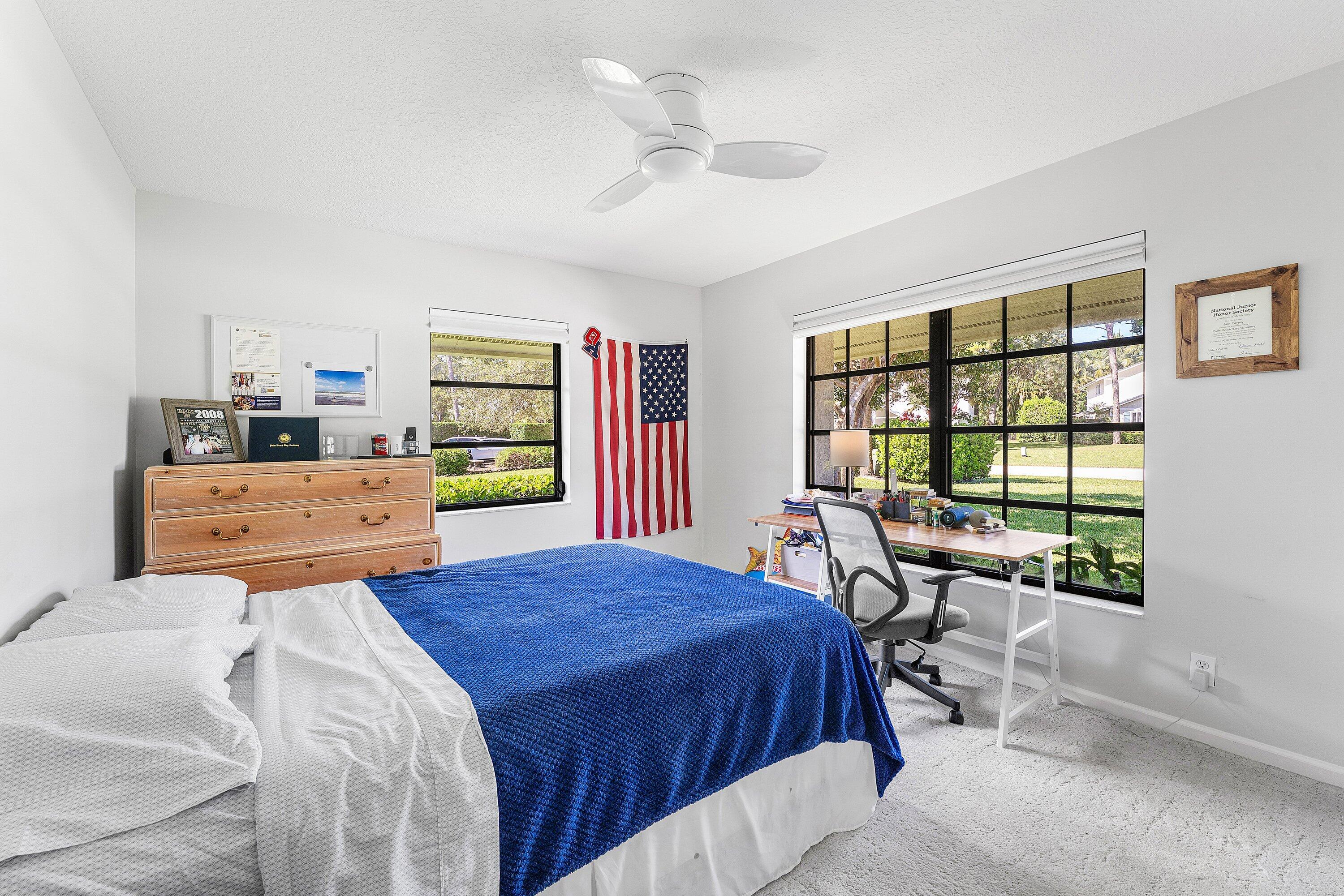 6048 Wood Lake Road Jupiter, FL 33458 - Photo 17 of 31 a bedroom with a bed and a table in it with window