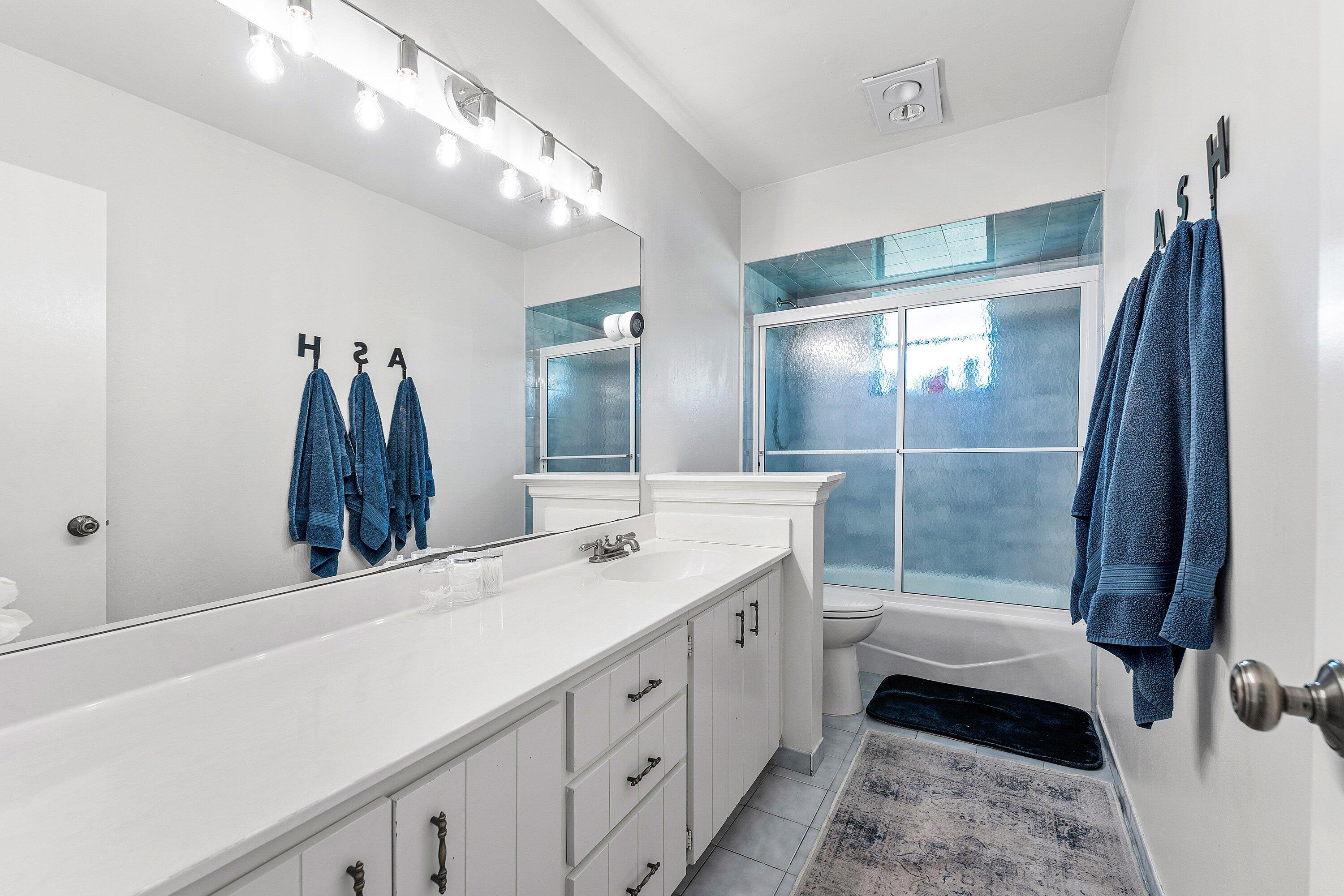 6048 Wood Lake Road Jupiter, FL 33458 - Photo 18 of 31 a bathroom with a double vanity sink and a mirror
