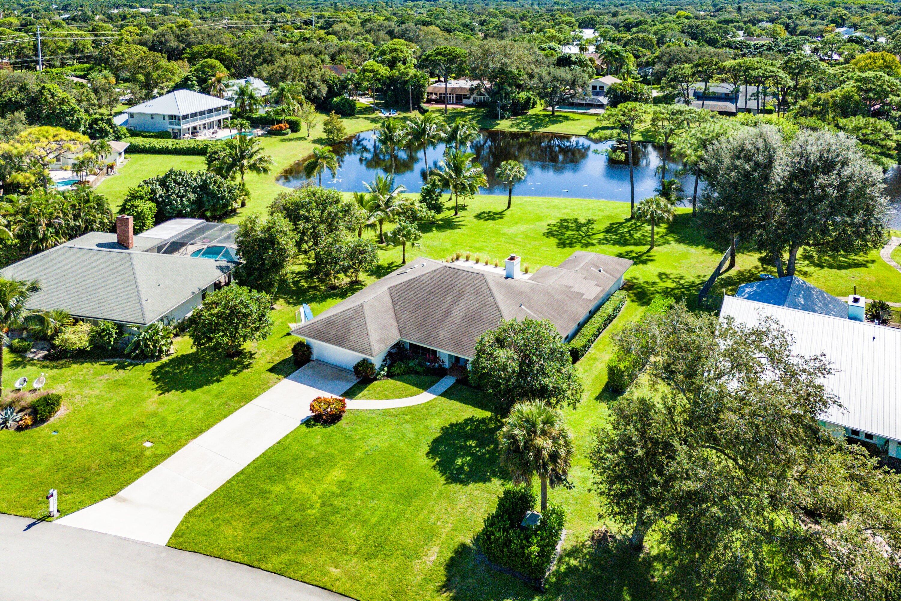 6048 Wood Lake Road Jupiter, FL 33458 - Photo 2 of 31 a view of a garden with swimming pool and trees