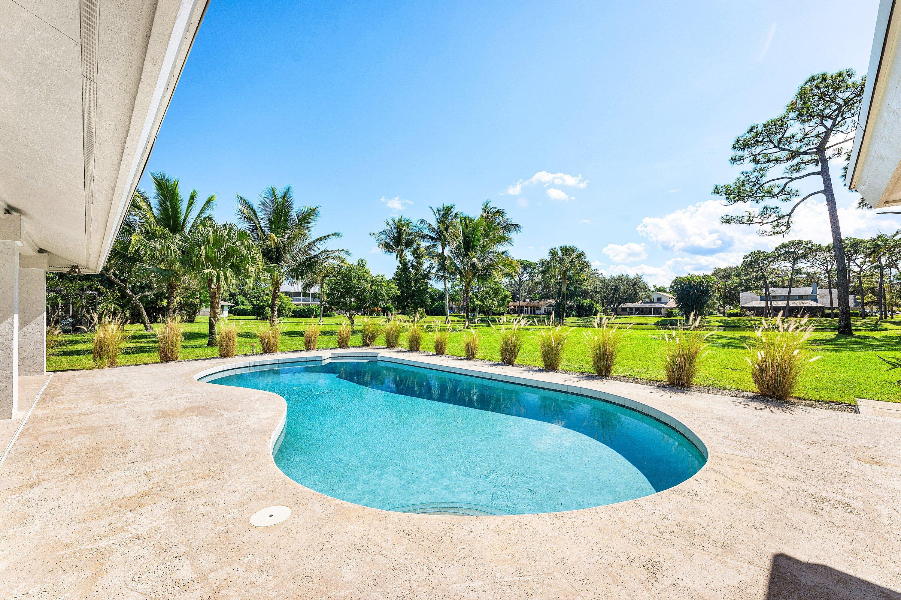 6048 Wood Lake Road Jupiter, FL 33458 - Photo 23 of 31 a view of a swimming pool and a yard