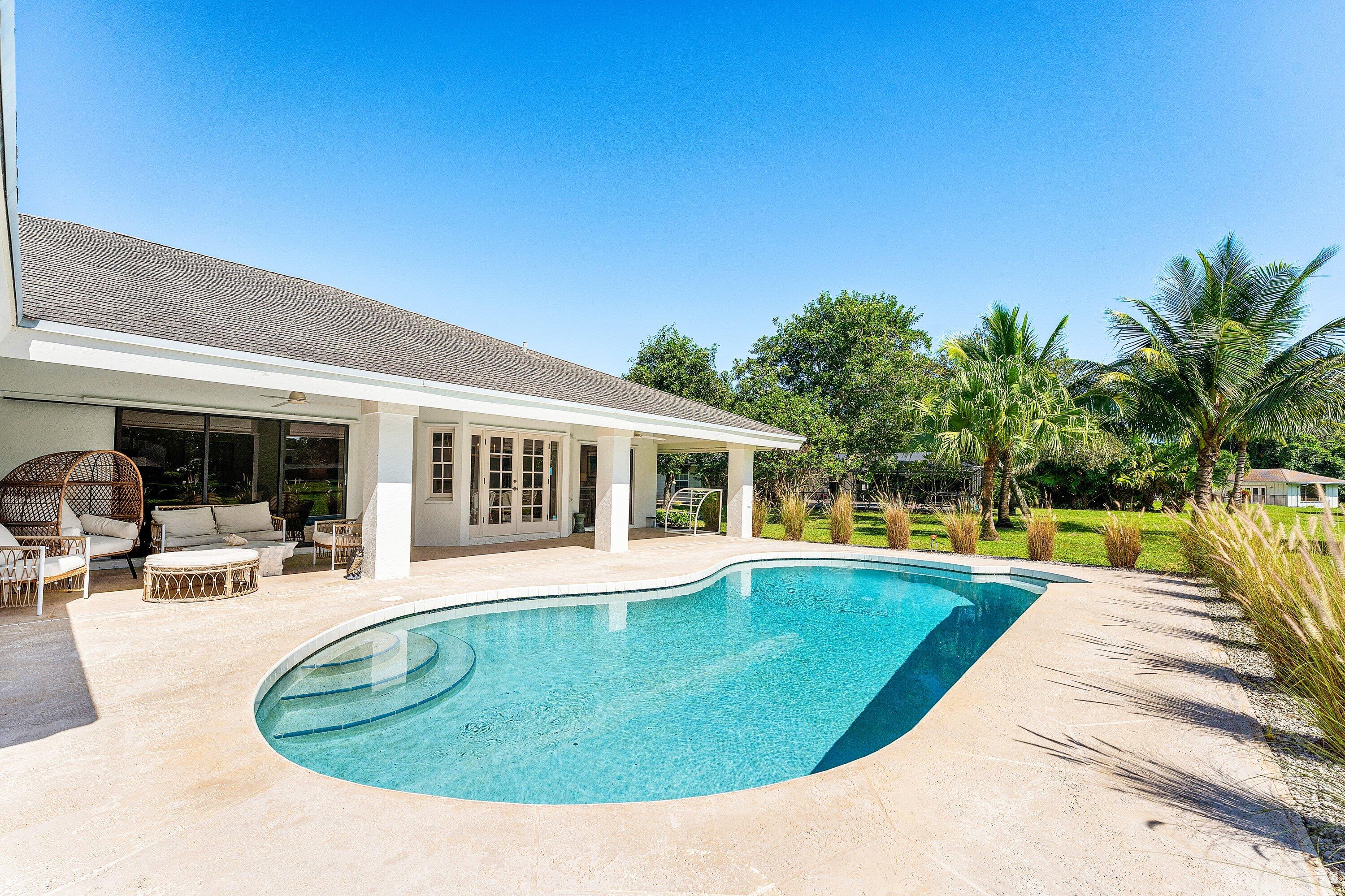 6048 Wood Lake Road Jupiter, FL 33458 - Photo 24 of 31 a view of a house with swimming pool and sitting area