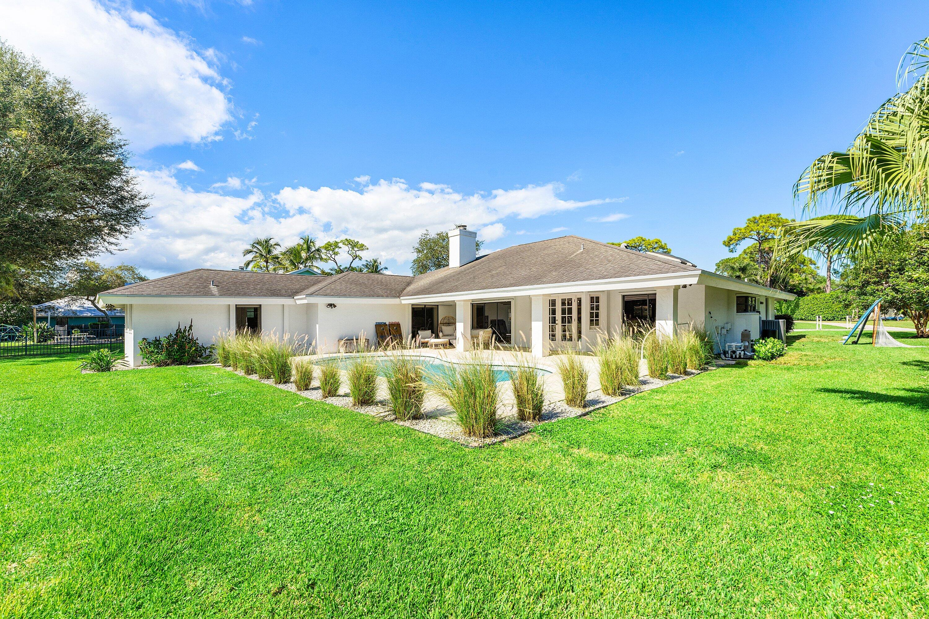 6048 Wood Lake Road Jupiter, FL 33458 - Photo 26 of 31 a front view of house with yard and green space