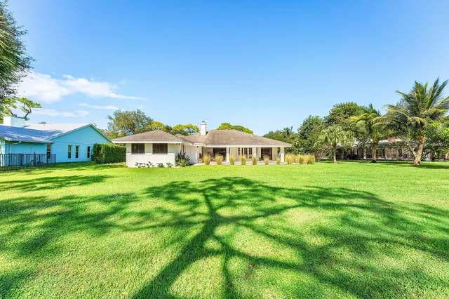 an aerial view of residential houses with outdoor space and trees all around