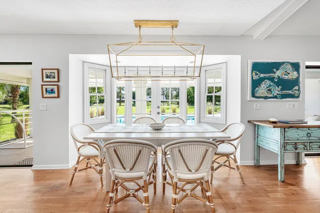 a dining room with furniture a chandelier and wooden floor