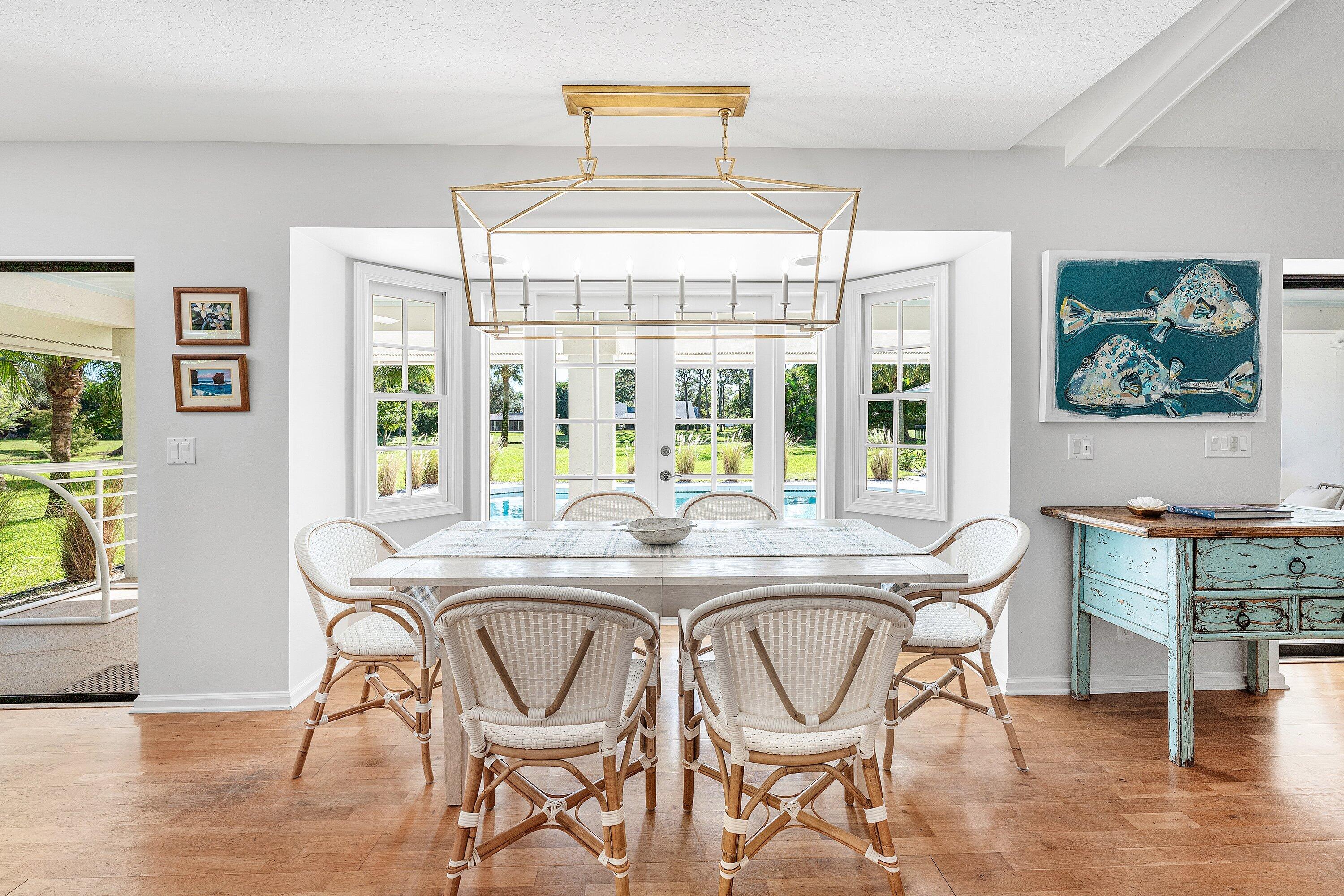6048 Wood Lake Road Jupiter, FL 33458 - Photo 4 of 31 a dining room with furniture a chandelier and wooden floor