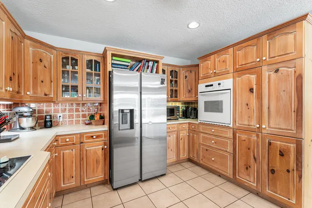 a kitchen with stainless steel appliances granite countertop a refrigerator and a stove top oven
