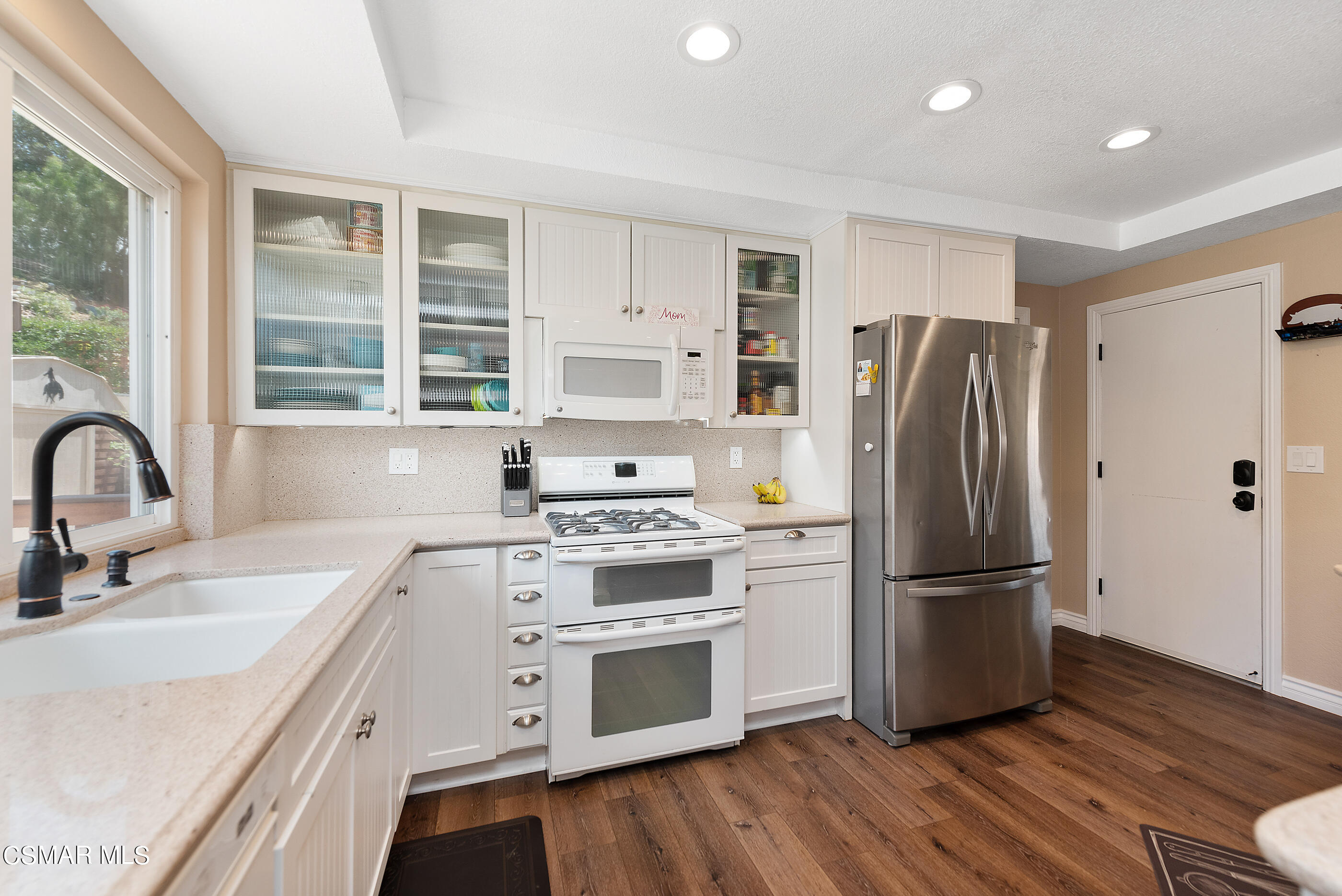 1137 Rambling Road Simi Valley, CA 93065 - Photo 13 of 77 a kitchen with stainless steel appliances a refrigerator sink and cabinets