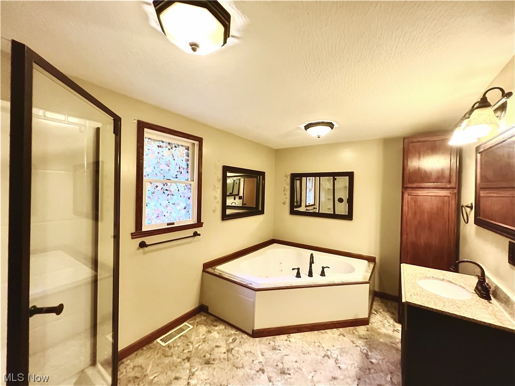 3122 Bedrock Road Northwest Dellroy, OH 44620 - Photo 18 of 23 Bathroom with tile floors, large vanity, shower with separate bathtub, and a textured ceiling