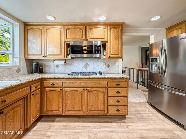 a kitchen with granite countertop a refrigerator stove and sink