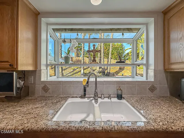 a bathroom with a granite countertop sink and a large mirror