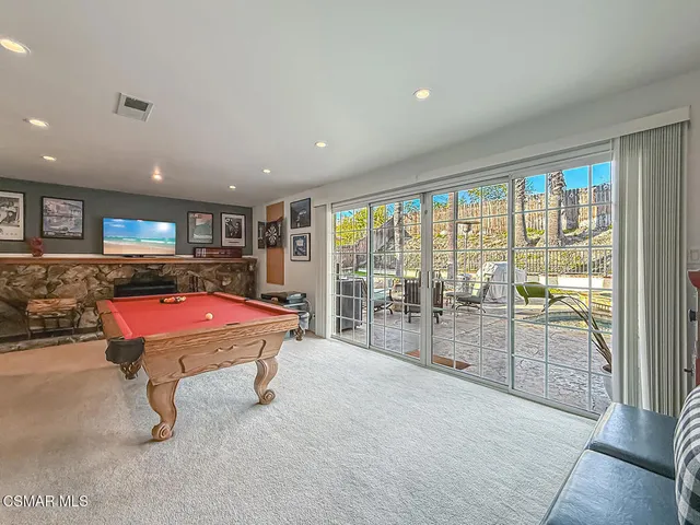 a room with table tennis pool table and glass door