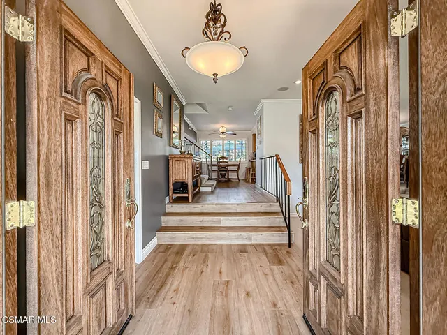 a view of a hallway with wooden floor and staircase