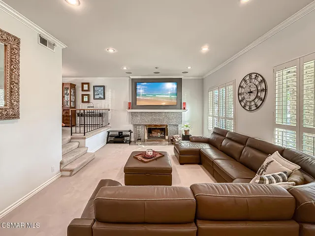 a living room with furniture a fireplace and a large window