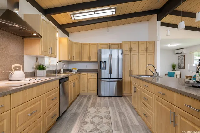 a kitchen with a sink dishwasher a refrigerator and cabinets with wooden floor