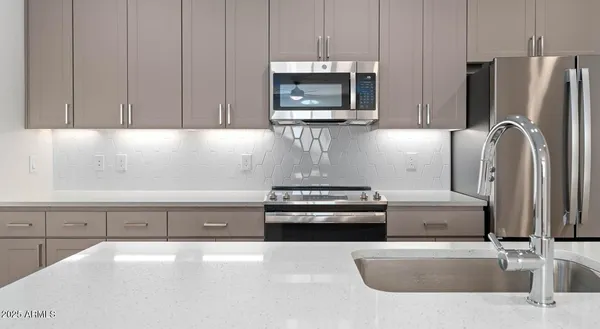 a kitchen with granite countertop a refrigerator and a stove top oven