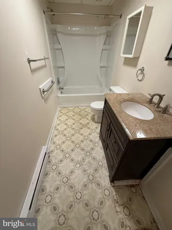 a bathroom with a granite countertop sink a toilet and a mirror