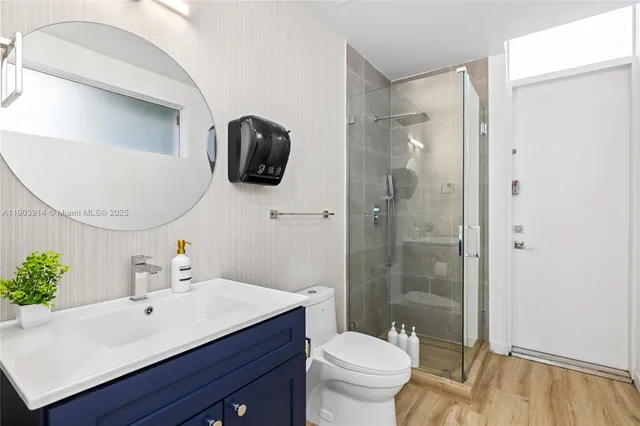 a bathroom with a sink a toilet and shower