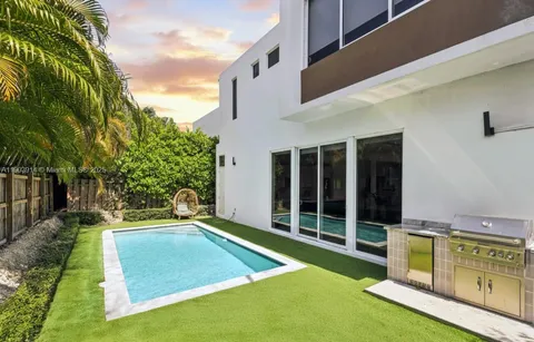a view of an house with backyard space and swimming pool