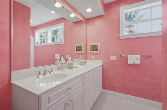 a bedroom with a bed a chandelier and a flat tv screen