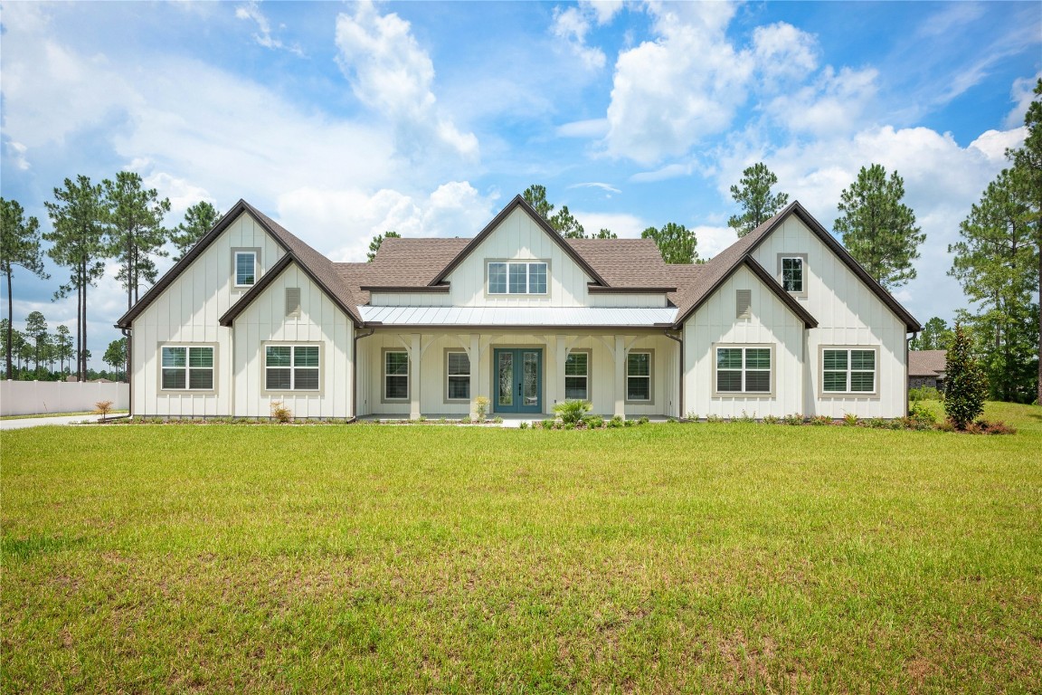 a front view of a house with a garden and trees