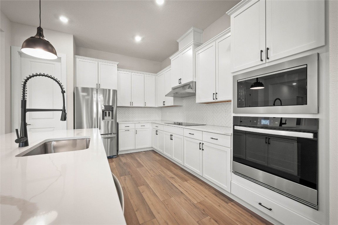 36199 Pitch Lane Hilliard, FL 32046 - Photo 24 of 40 a kitchen with stainless steel appliances granite countertop a stove microwave and sink