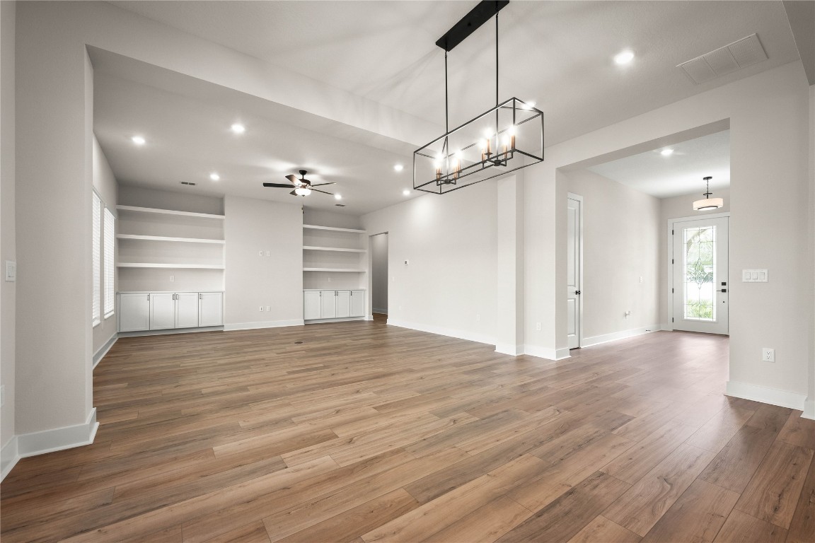 36199 Pitch Lane Hilliard, FL 32046 - Photo 3 of 40 a view of a room with wooden floor a ceiling fan and windows