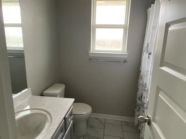 a white toilet sitting next to a window