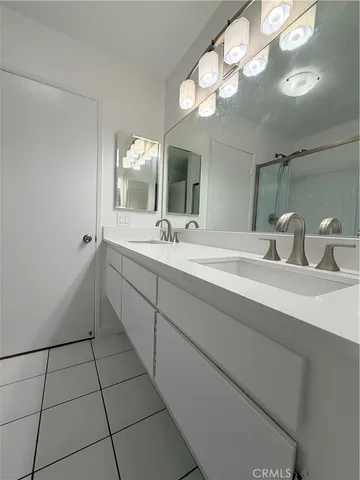 a bathroom with a sink a large mirror and a light fixture