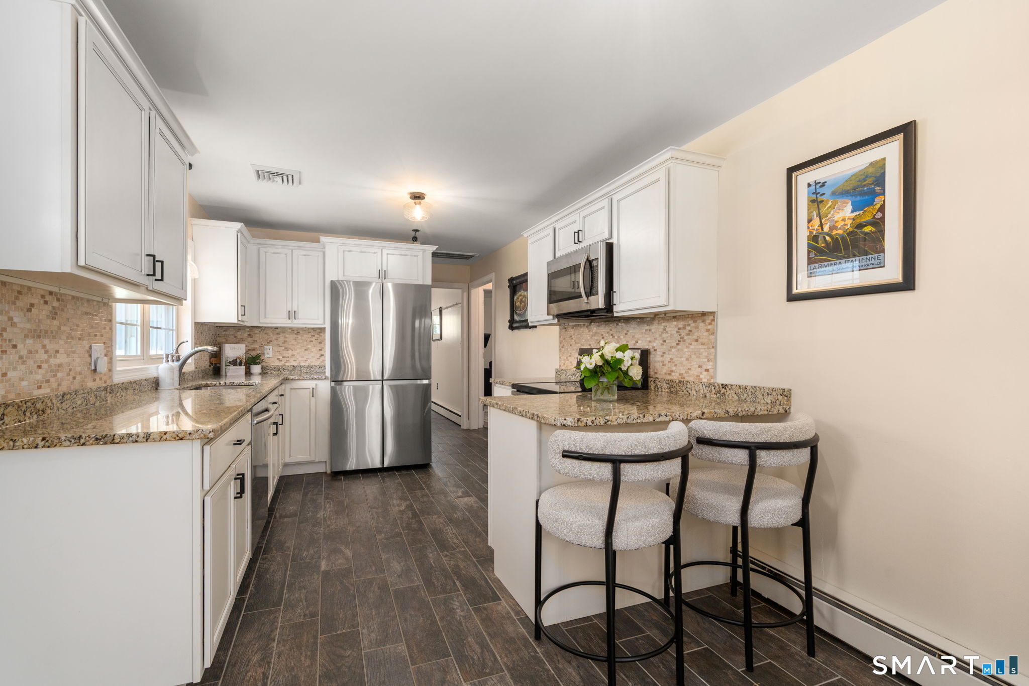 31 Cowan Street Suffield, CT 06078 - Photo 7 of 29 a kitchen with stainless steel appliances white cabinets and wooden floor