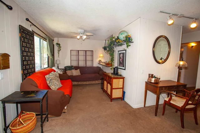 a living room with furniture a chandelier and a mirror