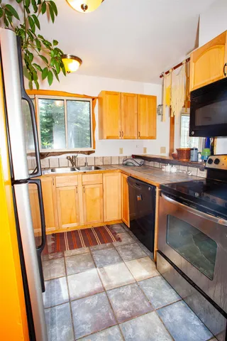 a kitchen with stainless steel appliances granite countertop a stove a sink and a microwave