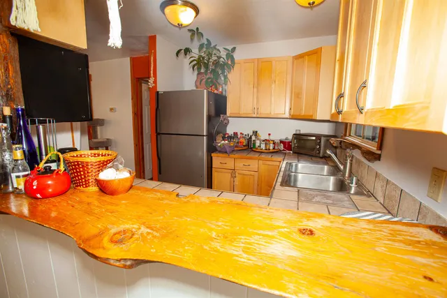 a kitchen with stainless steel appliances wooden floor and a refrigerator