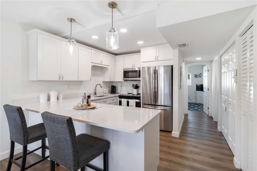 5416 Swift Road, Unit 27 Sarasota, FL 34231 - Photo 16 of 55 a kitchen with refrigerator cabinets dining table and chairs