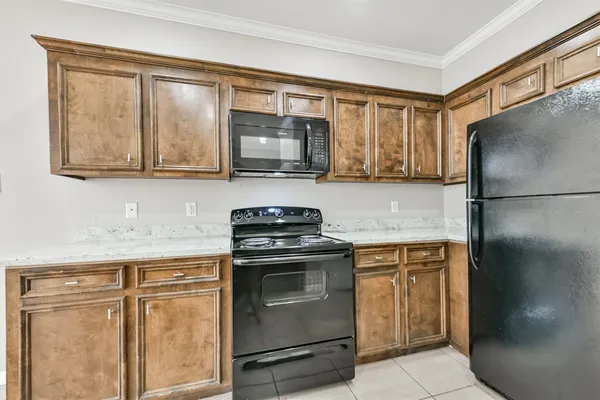 a kitchen with stainless steel appliances granite countertop a refrigerator a stove a sink and a microwave